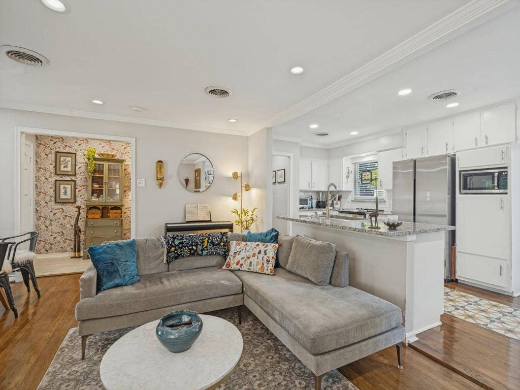 200 S Weatherred Drive, Richardson, TX 75080 Kitchen featuring white shaker-style cabinetry, stone-surface countertops, and stainless steel appliances, complemented by wood-finish flooring and recessed lighting throughout