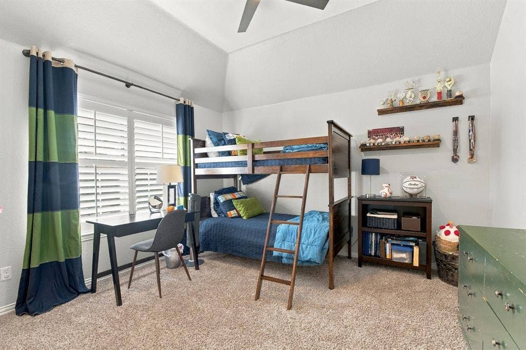 Vaulted ceilings, carpeted flooring, white plantation shutters, and a ceiling fan