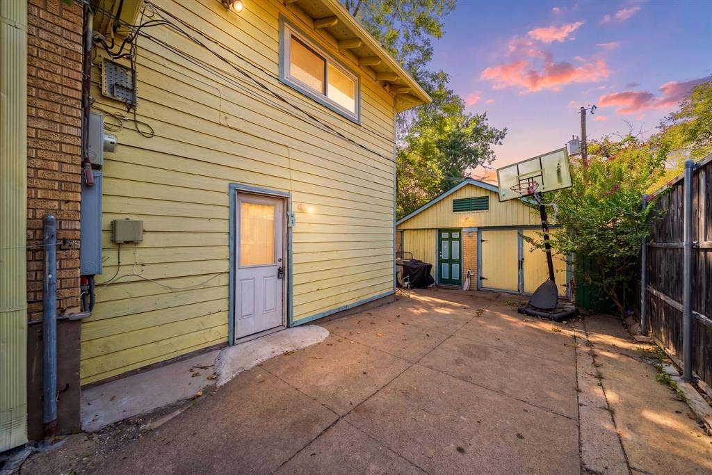2807 Cain Boulevard, Dallas, TX 75211 Paved concrete driveway with a detached auxiliary building featuring a double entry door and a separate utility door