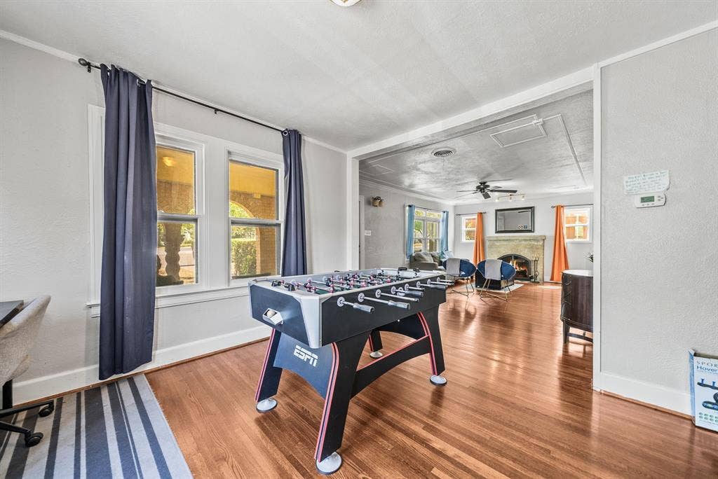 2807 Cain Boulevard, Dallas, TX 75211 Wood-finish flooring extending throughout, multiple windows with natural light, and a living area featuring a stone fireplace