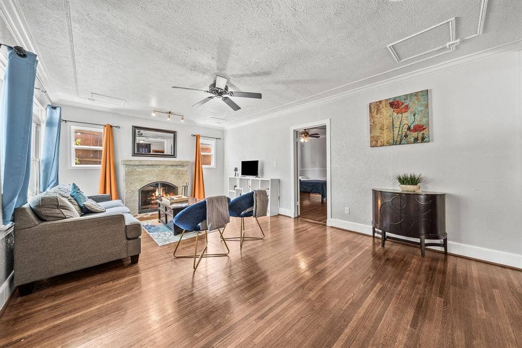 2807 Cain Boulevard, Dallas, TX 75211 Hardwood flooring, fireplace with stone surround, ceiling fan, crown molding, and white baseboards