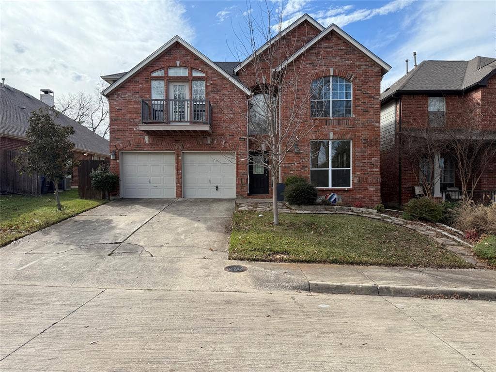 2254 Ash Grove Way, Dallas, TX 75228 Two-story brick exterior featuring a second-story balcony, arched window detailing, and a two-car garage