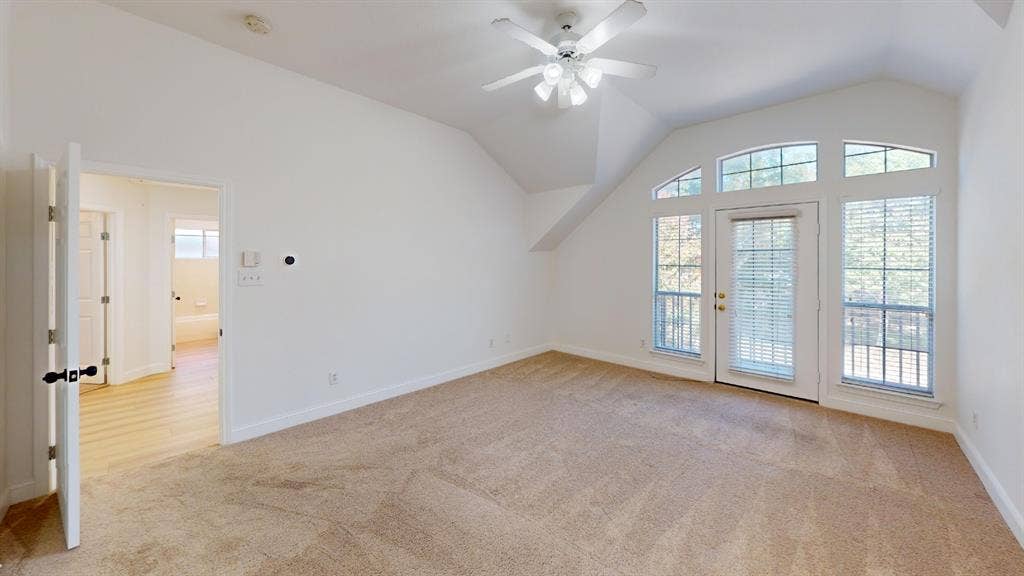 2254 Ash Grove Way, Dallas, TX 75228 Vaulted ceilings, neutral carpeting, arch-top windows, and a glass-paneled exterior door with integrated blinds