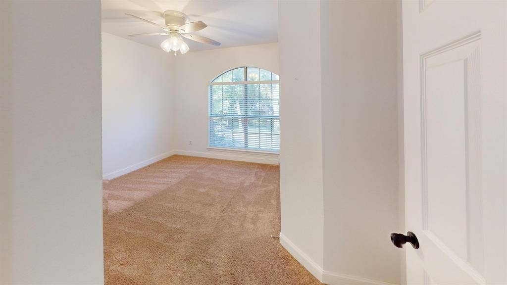 2254 Ash Grove Way, Dallas, TX 75228 Room featuring neutral wall-to-wall carpeting, an arched window with horizontal blinds, and a ceiling-mounted light fixture with a central fan