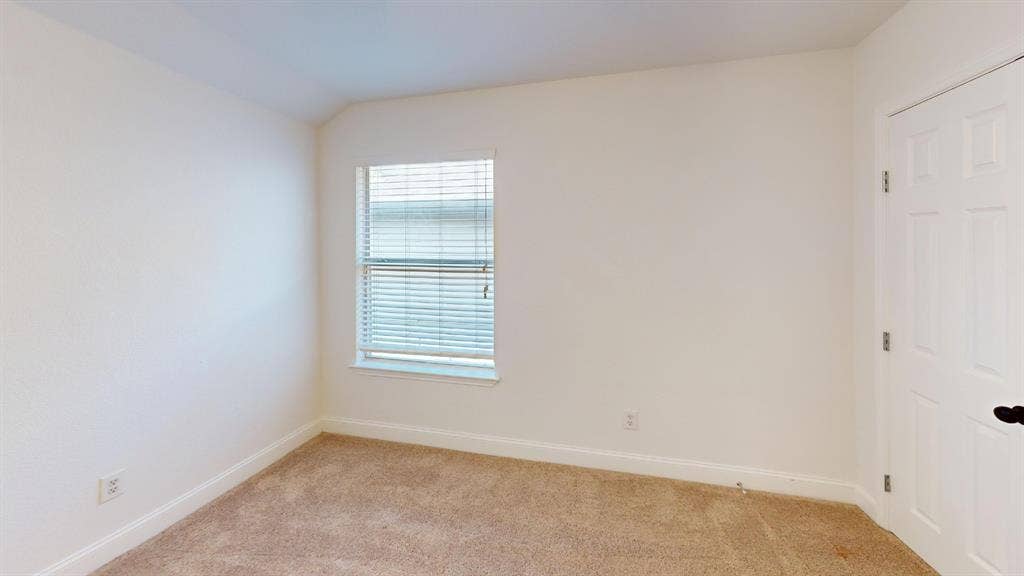 2254 Ash Grove Way, Dallas, TX 75228 Room featuring neutral-toned carpeting, off-white wall finishes, a single-pane window with horizontal blinds, and a white interior door with dark hardware