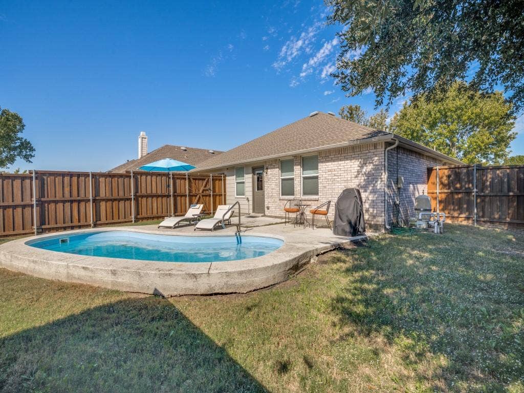 1728 Harvest Crossing Drive, Wylie, TX 75098 Exterior space featuring a concrete-encased pool, a paved patio, and perimeter wood privacy fencing