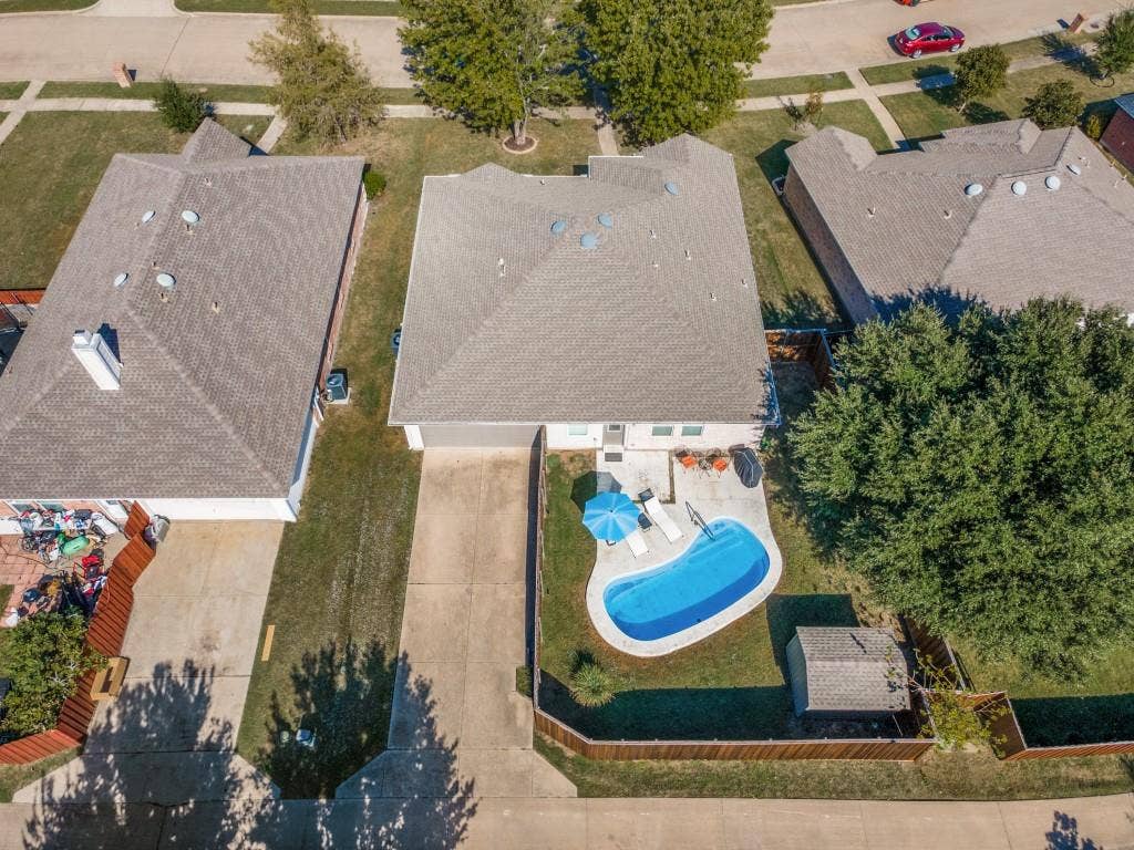 1728 Harvest Crossing Drive, Wylie, TX 75098 Aerial perspective of a property featuring an in-ground swimming pool, concrete patio, fenced backyard, and a detached storage shed