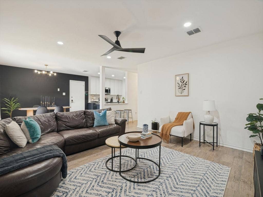 1728 Harvest Crossing Drive, Wylie, TX 75098 Open-concept interior featuring wood-finish flooring, a matte black three-blade ceiling fan, recessed lighting, and a contrasting charcoal-colored accent wall