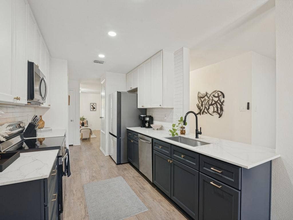 1728 Harvest Crossing Drive, Wylie, TX 75098 Kitchen featuring dual-tone cabinetry, stone-finish countertops, stainless steel appliances, a white tile backsplash, and wood-finish flooring