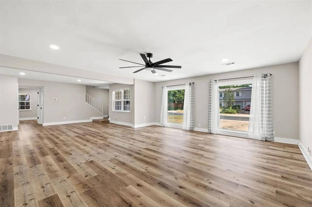 Open-concept interior featuring wood-finish flooring, recessed lighting, a ceiling fan, and large windows