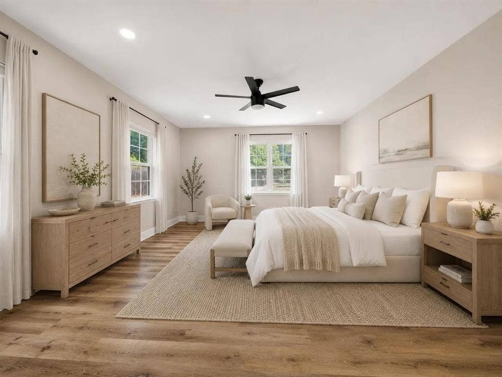 Neutral-toned interior featuring wood-finish flooring, recessed lighting, double-hung windows, and a matte black ceiling fan