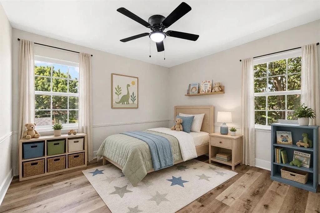 Wood-finish flooring, wainscoting, dual windows with grid detailing, and a ceiling-mounted light fixture with a central fan