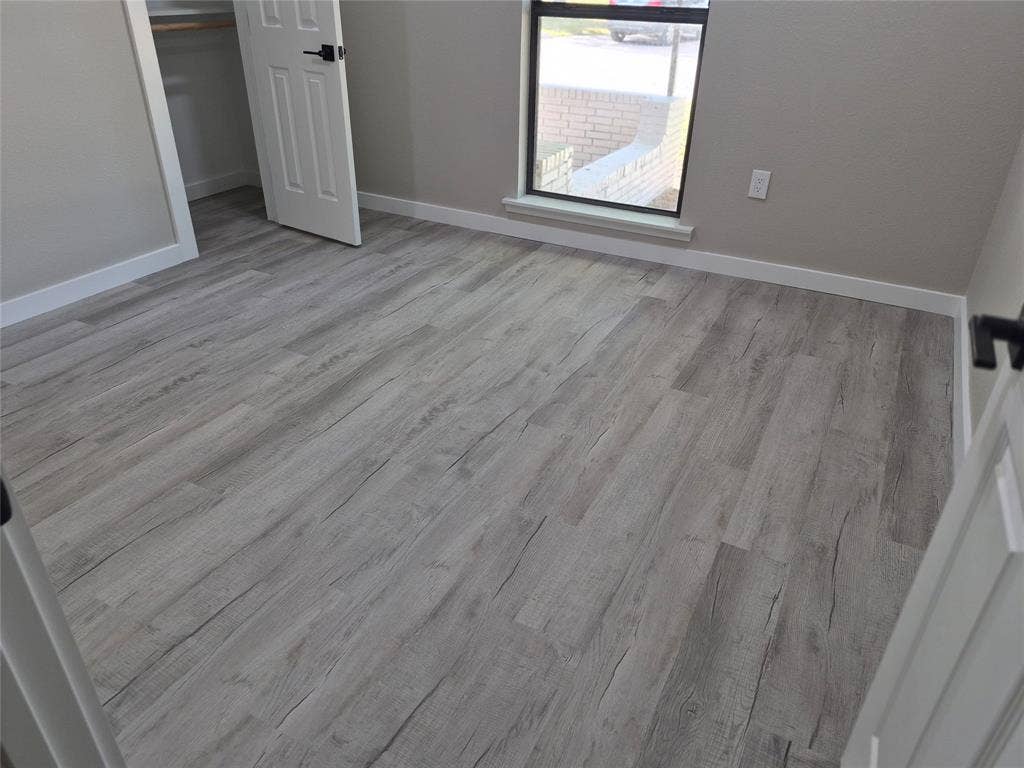 2029 Roberts Drive, Granbury, TX 76048 Room featuring wood-finish flooring, a neutral color palette, a single-pane window, and a built-in closet with a panel door