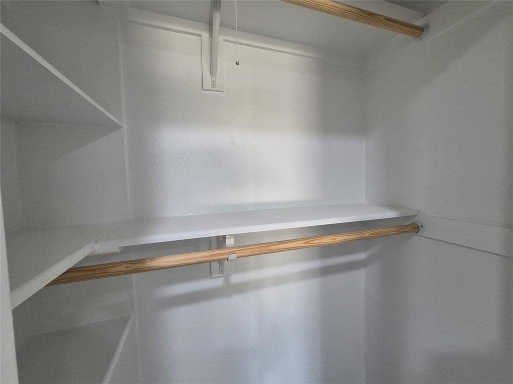 2029 Roberts Drive, Granbury, TX 76048 Storage closet featuring white-finished shelving and wooden clothing rods