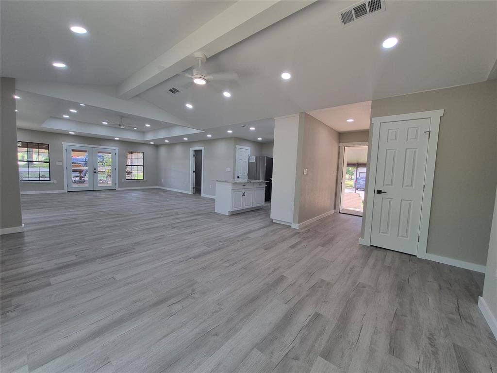 2029 Roberts Drive, Granbury, TX 76048 Open-concept interior featuring wood-finish flooring, recessed lighting, vaulted ceilings with dual paddle fans, and a center island with light-toned countertop
