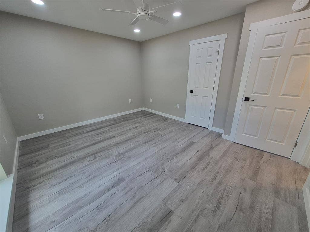 2029 Roberts Drive, Granbury, TX 76048 Neutral interior space featuring wood-finish flooring, recessed lighting, a ceiling fan, and six-panel doors with matte black hardware