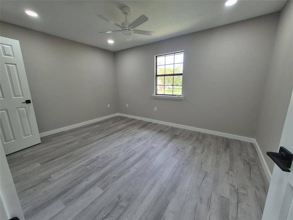 2029 Roberts Drive, Granbury, TX 76048 Interior room featuring wood-finish flooring, recessed lighting, a ceiling fan, and a single-hung window with black hardware accents