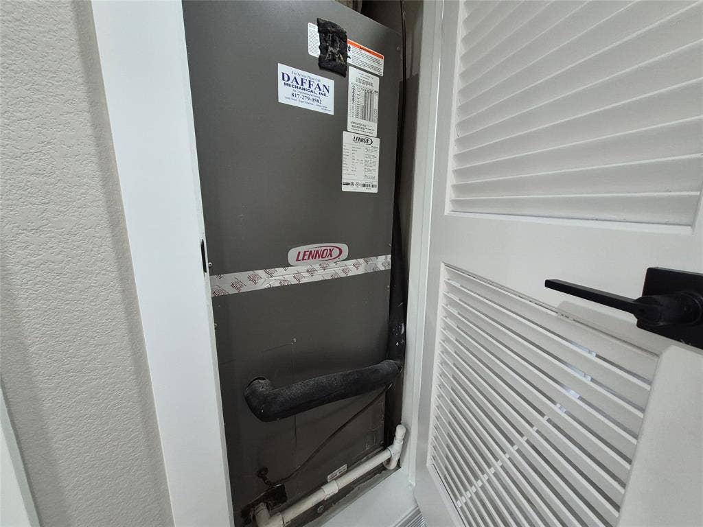 2029 Roberts Drive, Granbury, TX 76048 Lennox HVAC unit housed within a closet featuring a white louvered door and matte black hardware