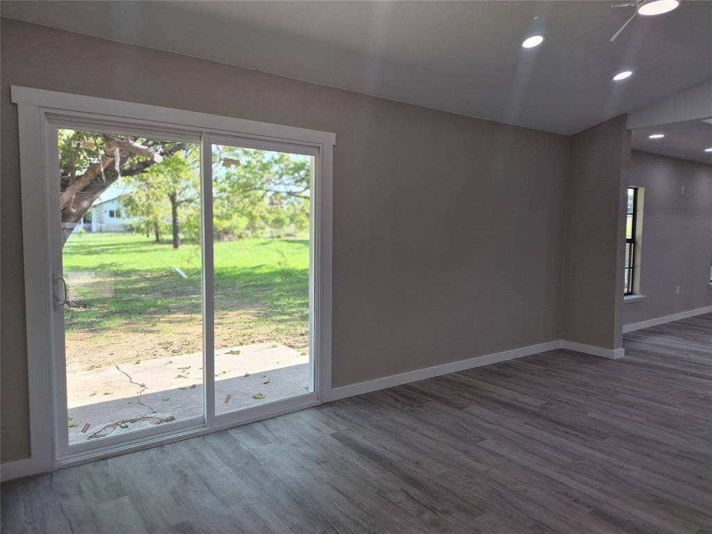 2029 Roberts Drive, Granbury, TX 76048 Sliding glass door with white frame, wood-finish flooring, vaulted ceiling, and recessed lighting
