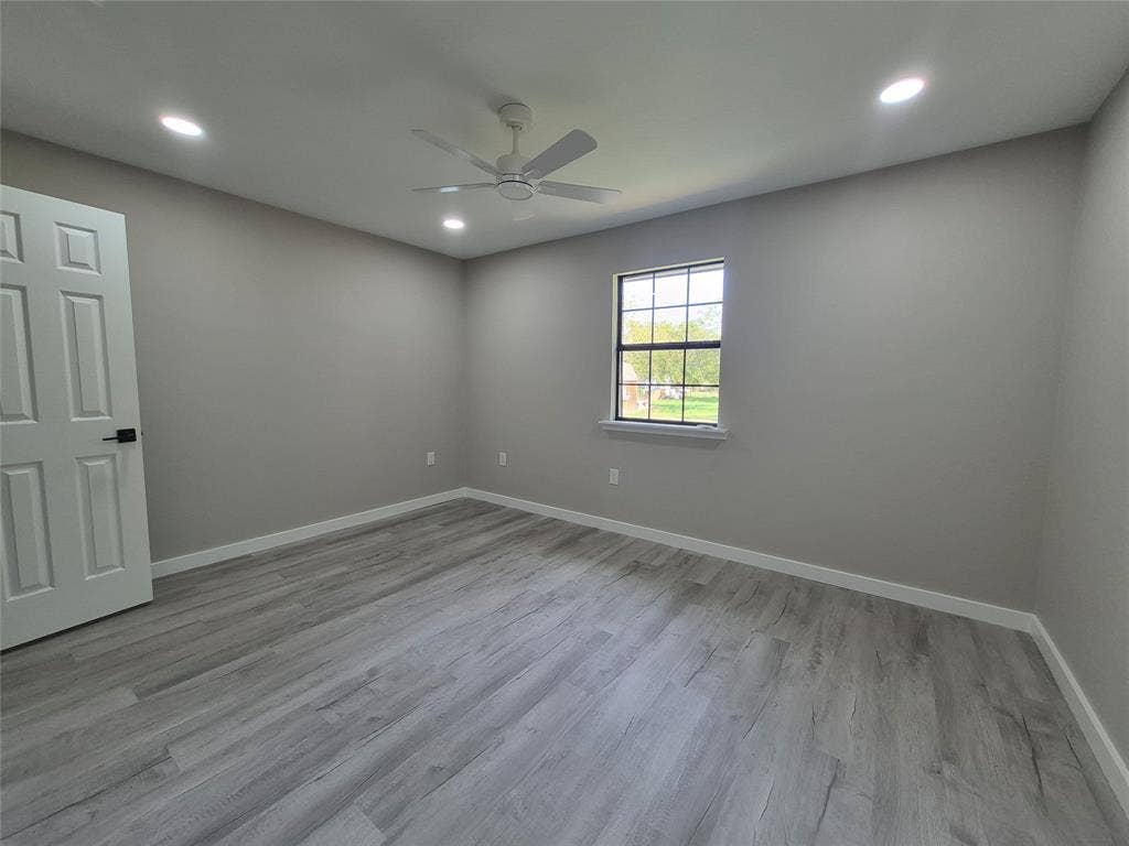 2029 Roberts Drive, Granbury, TX 76048 Neutral-toned room featuring wood-finish flooring, recessed lighting, a ceiling fan, and a grid-pane window