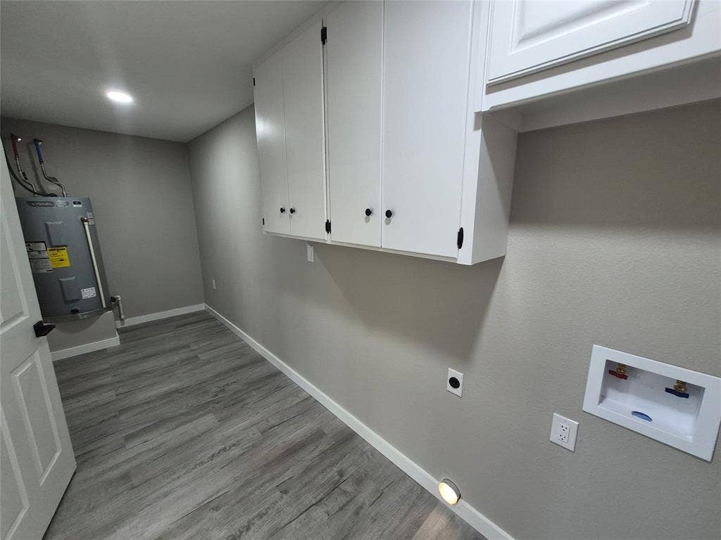 2029 Roberts Drive, Granbury, TX 76048 Utility area featuring wood-finish flooring, white wall-mounted cabinetry, recessed lighting, and dedicated water and electrical hookups
