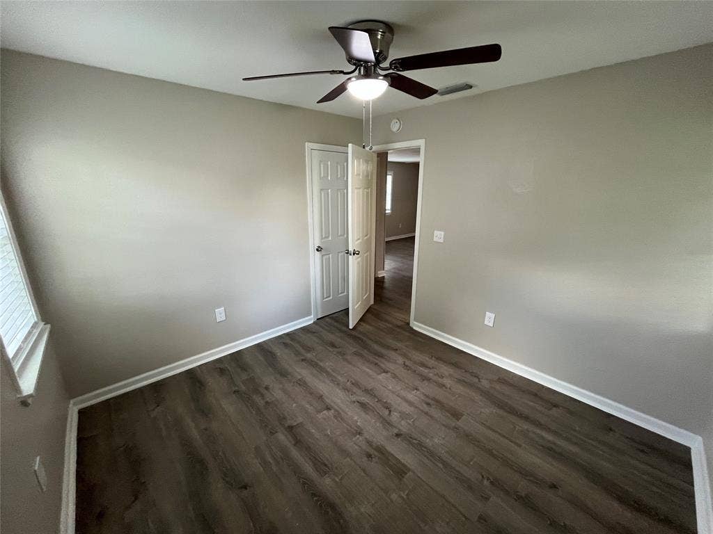 6415 Godfrey Avenue, Dallas, TX 75217 Room interior featuring wood-finish flooring, neutral wall paint, and a ceiling-mounted light fixture with a fan