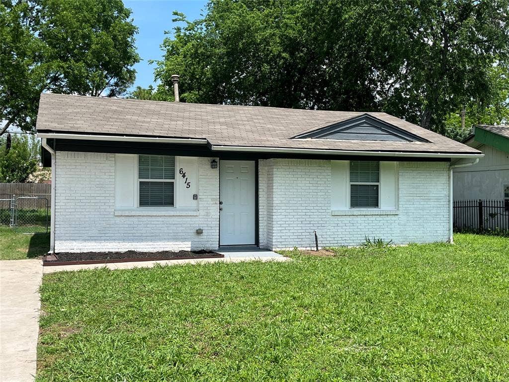 6415 Godfrey Avenue, Dallas, TX 75217 Single-story residence featuring white brick exterior, asphalt shingle gable roof, front-facing triangular gable vent, and concrete walkway