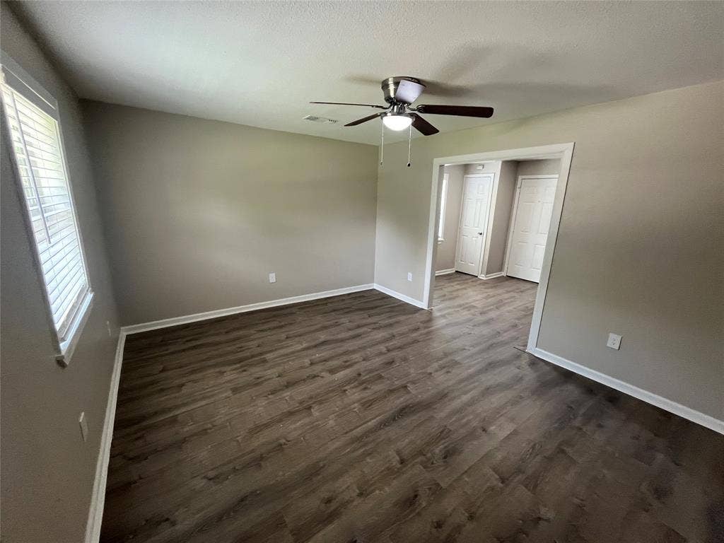 6415 Godfrey Avenue, Dallas, TX 75217 Wood-finish flooring, neutral wall tones, multi-blade ceiling fan with integrated lighting, and white six-panel interior doors