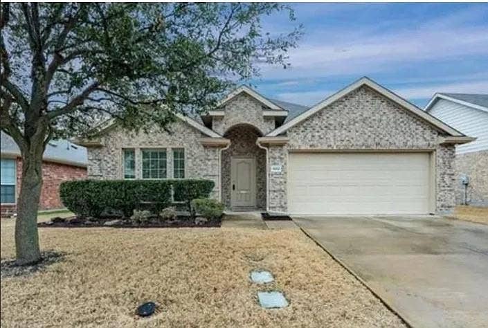 1000 Buffalo Creek Drive, McKinney, TX 75072 Single-story brick exterior featuring a covered entryway, an attached two-car garage, and multi-pane windows