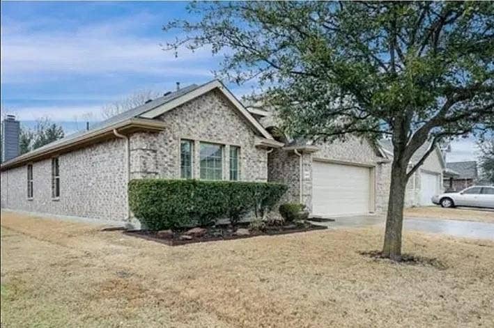 1000 Buffalo Creek Drive, McKinney, TX 75072 Single-story exterior featuring light-toned brick masonry, a multi-gabled roofline, an attached multi-car garage, and established landscaping