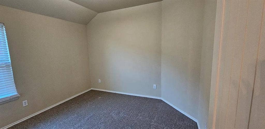 1000 Buffalo Creek Drive, McKinney, TX 75072 Interior space featuring neutral wall paint, high-texture carpeting, a single-pane window with horizontal blinds, and a slanted ceiling