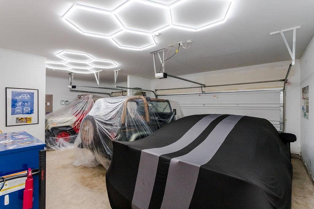 3-car garage featuring recessed hexagonal LED light fixtures and an automated garage door opener