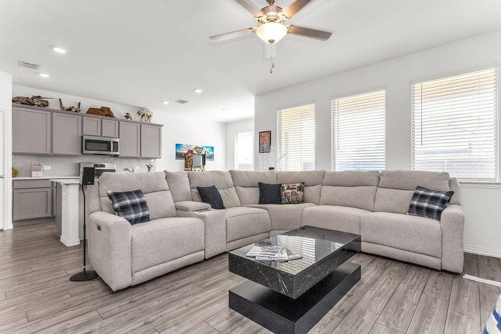 Open-concept space featuring vinyl flooring, grey cabinetry, neutral wall tones, recessed lighting, and a multi-blade ceiling fan