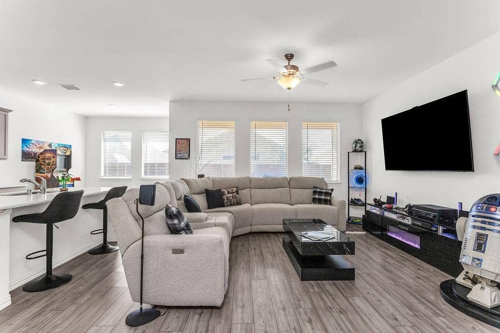 Open concept space featuring vinyl flooring, recessed lighting, a ceiling fan, and large windows with horizontal blinds
