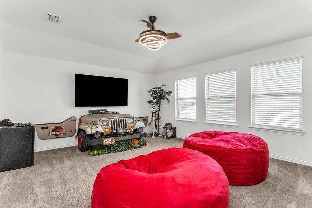 Tray ceiling, carpeted flooring, and modern circular LED ceiling fan with retractable blades