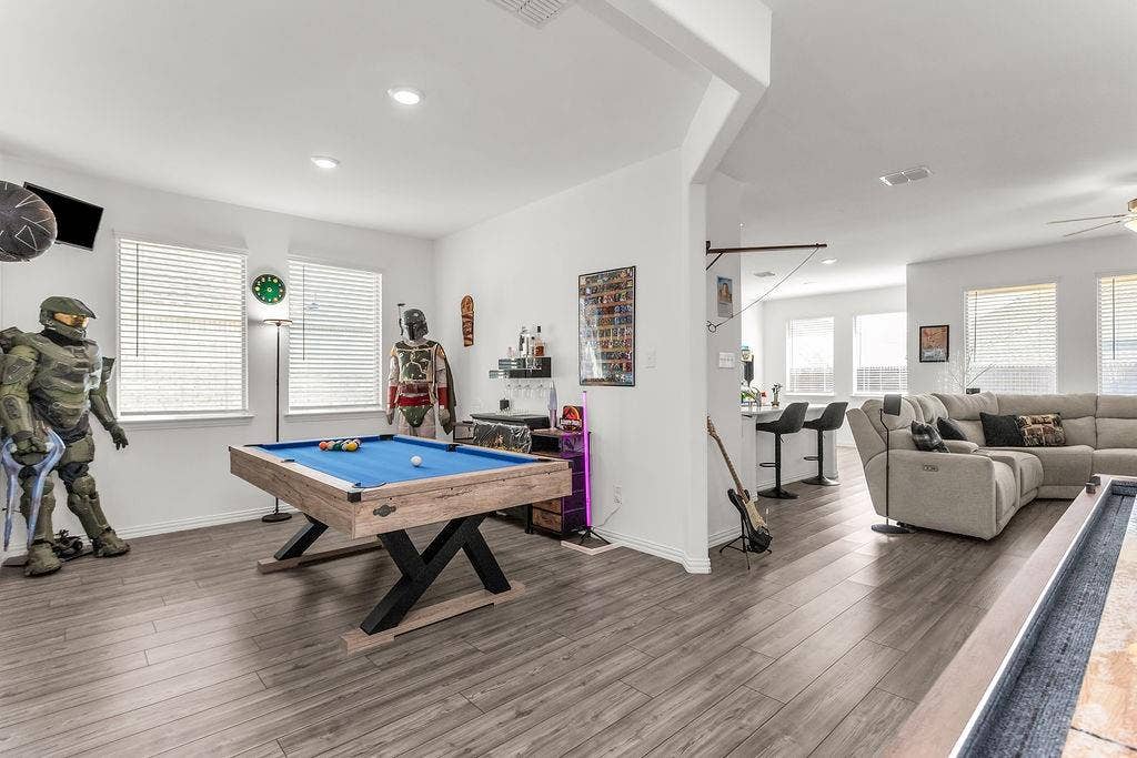Open-concept interior featuring vinyl flooring, recessed lighting, and multiple windows with horizontal blinds