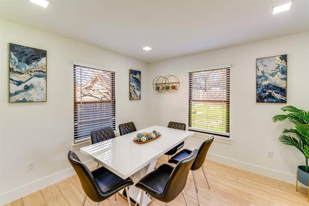 Neutral-toned walls, wood-finish flooring, recessed lighting, and windows equipped with horizontal blinds