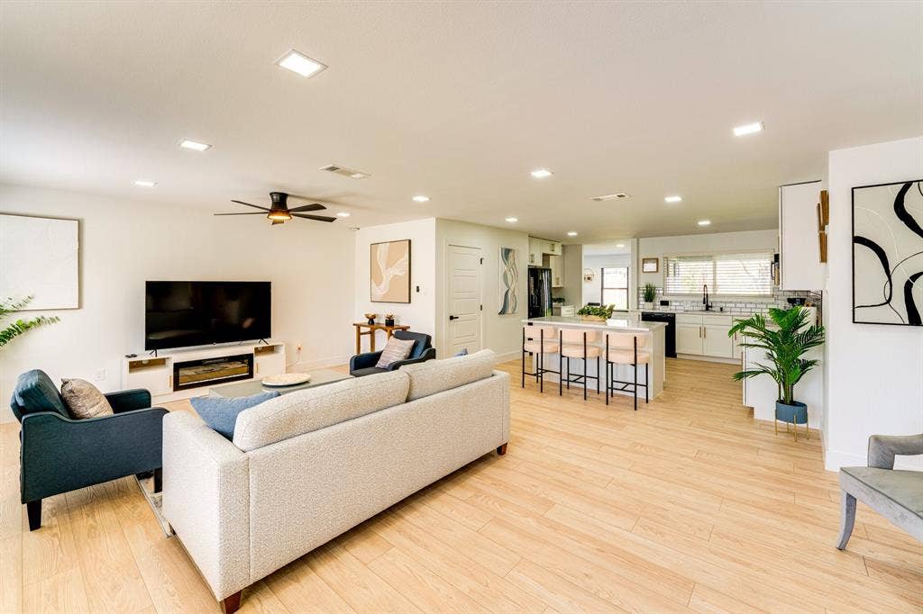 Open-concept interior featuring wood-finish flooring, recessed lighting, and a kitchen island with stone-surface countertop