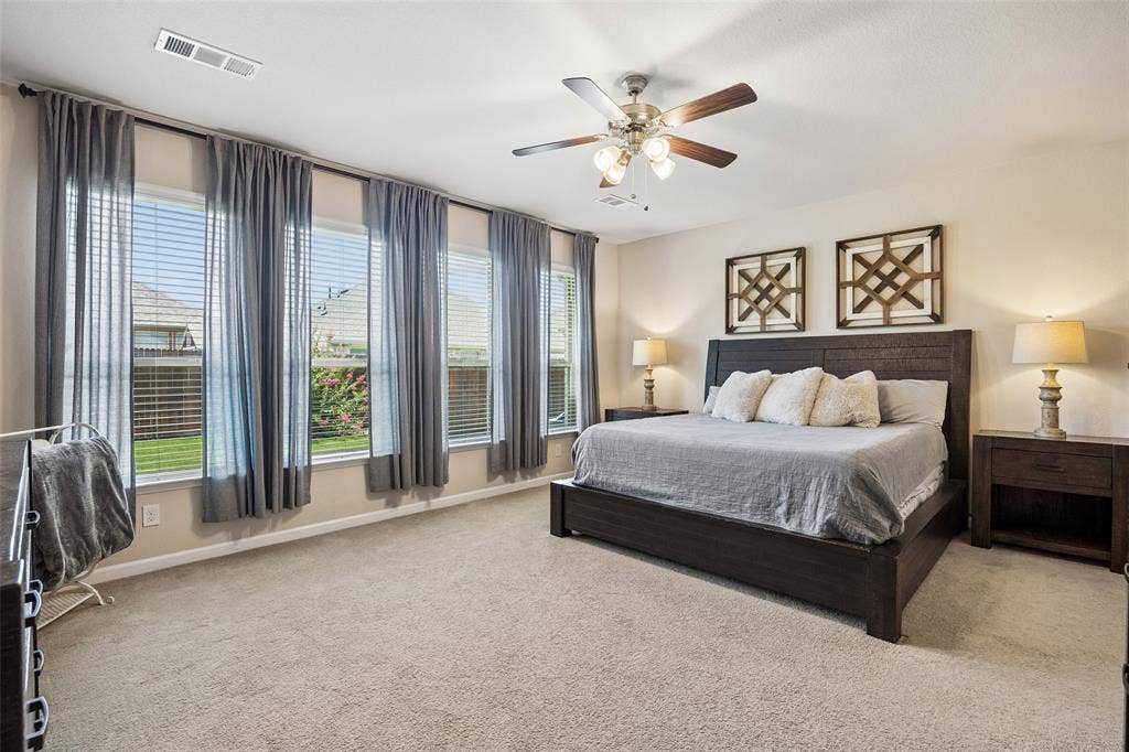 1321 Meridian Drive, Forney, TX 75126 Primary bedroom featuring multiple windows with views of the backyard