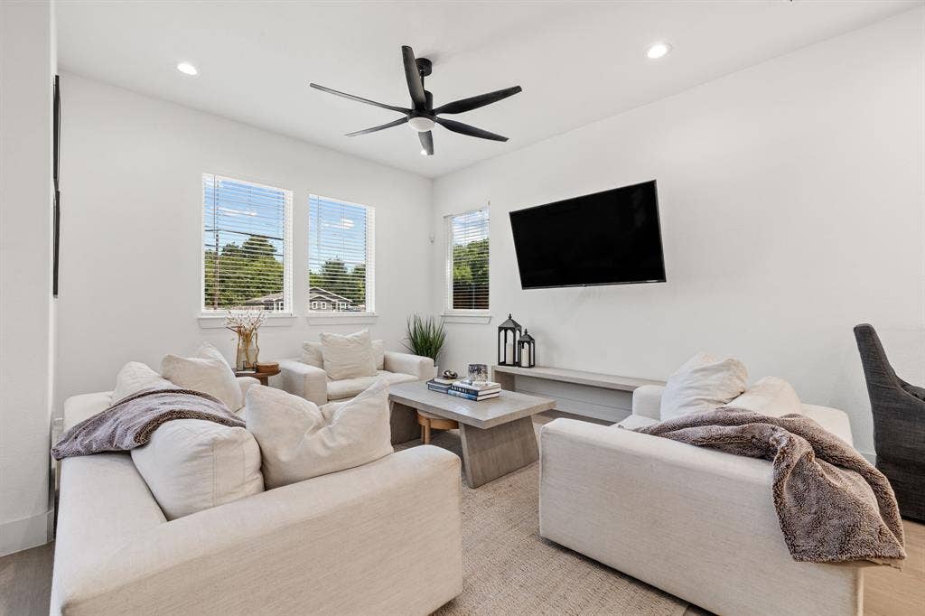 2502 Elsie Faye Heggins Street, Dallas, TX 75215 Living area featuring high ceilings, recessed lighting, a multi-blade ceiling fan, three windows with horizontal blinds, and a built-in floating shelf