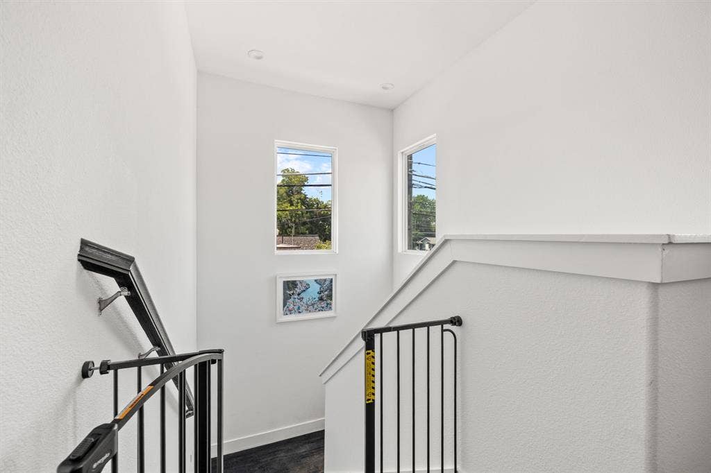2502 Elsie Faye Heggins Street, Dallas, TX 75215 Staircase featuring dark-toned railings, recessed ceiling lighting, and multiple windows providing natural illumination