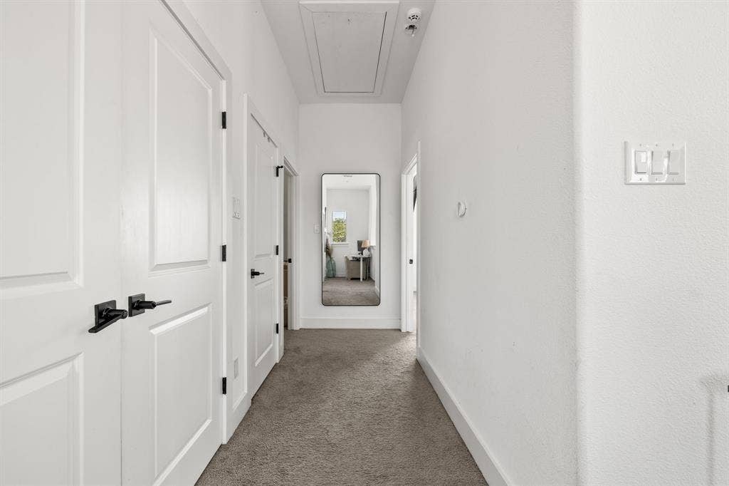 2502 Elsie Faye Heggins Street, Dallas, TX 75215 Hallway featuring neutral carpeted flooring, paneled interior doors, and matte black hardware