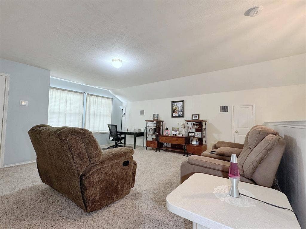 4102 Maidstone Drive, Garland, TX 75043 Wide view of the furnished living room, showing its seating area, light-colored walls, ceiling detail, and connection to the adjoining interior spaces.