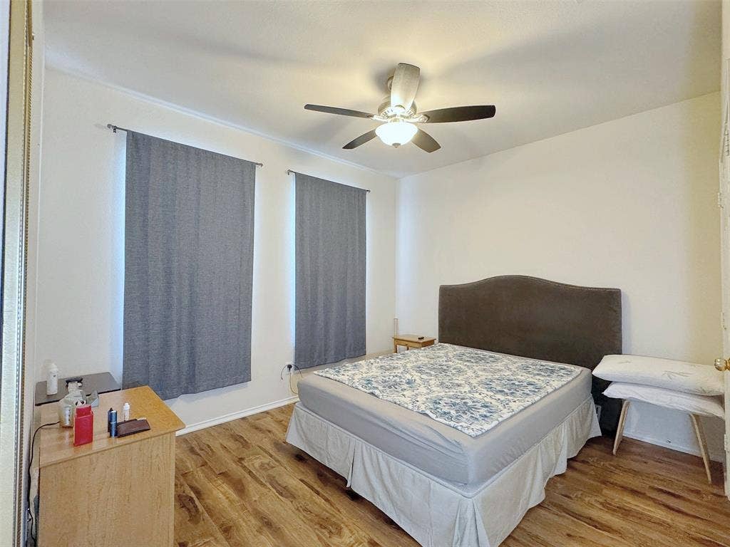 4102 Maidstone Drive, Garland, TX 75043 Bedroom with wood-look flooring, a ceiling fan with light, window coverings, and furnishings that illustrate the room layout.