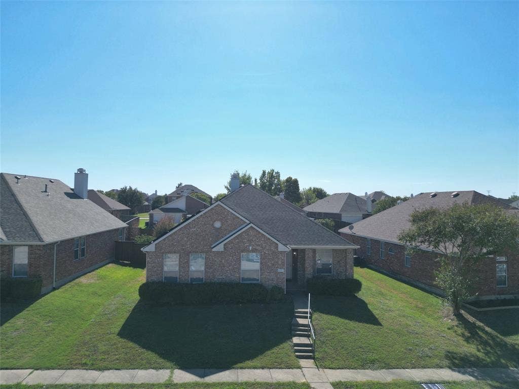 4102 Maidstone Drive, Garland, TX 75043 Additional elevated front view showing the house, lawn, roofline, and its position beside neighboring homes.