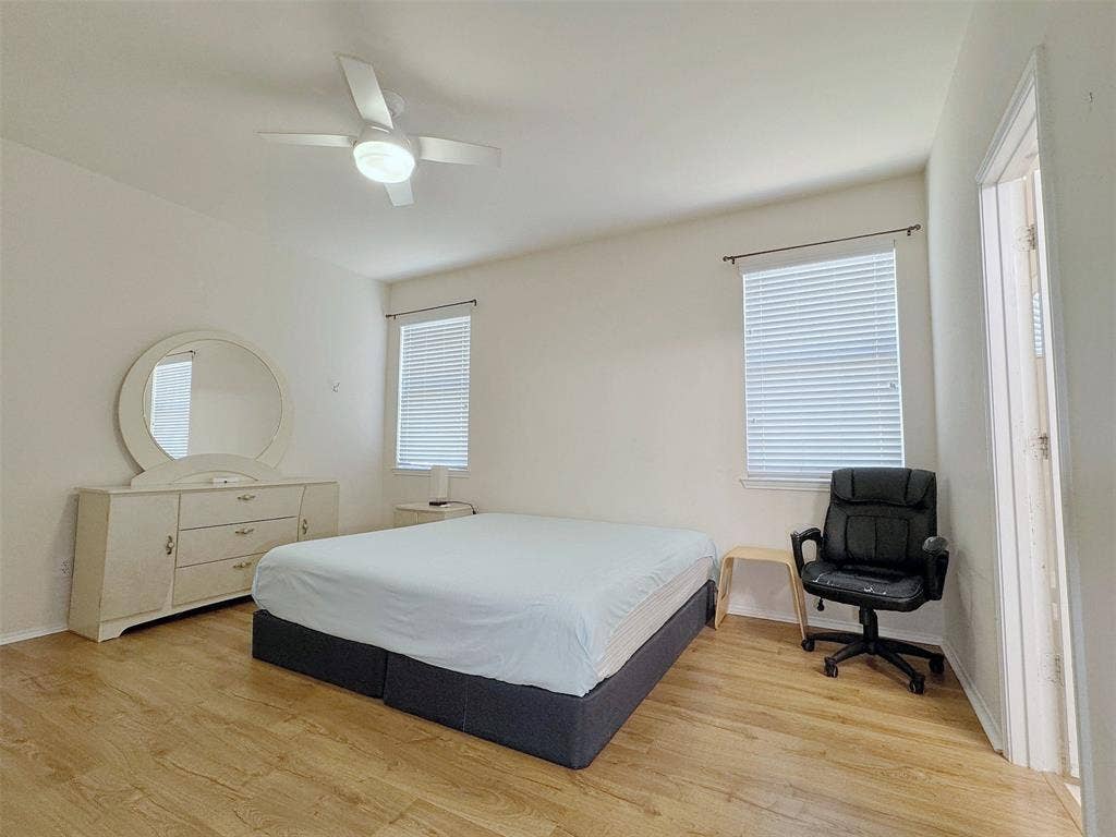 4102 Maidstone Drive, Garland, TX 75043 Alternate angle of the same bedroom, showing the window placement, wood-look flooring, and arrangement of the bed and furnishings.