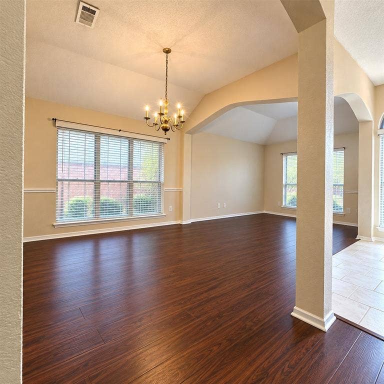 1931 Cutler Drive, Mesquite, TX 75149 Vaulted ceilings featuring decorative arched architectural detailing, wood-finish flooring, multi-pane windows, and a traditional six-arm chandelier