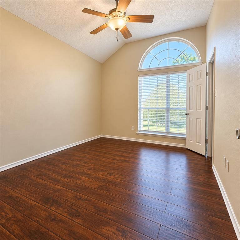1931 Cutler Drive, Mesquite, TX 75149 Vaulted ceiling, wood-finish flooring, arched transom window, and ceiling fan with integrated light fixture