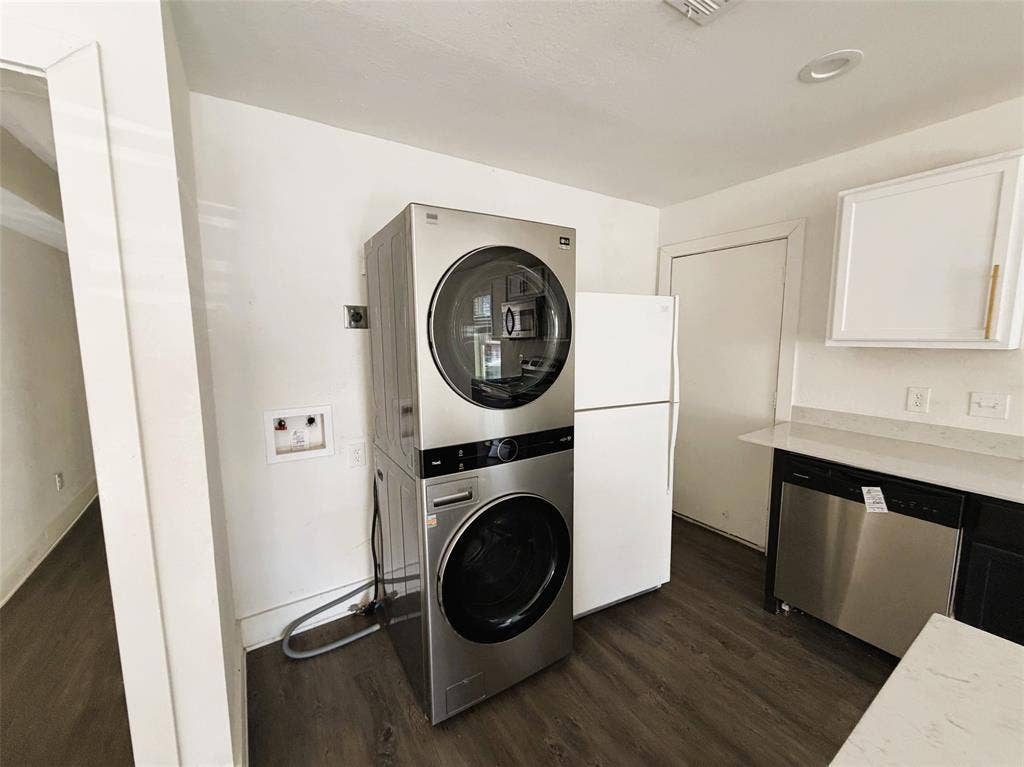 Laundry in kitchen with stackable and fridge