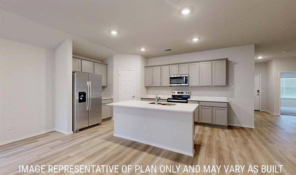 3213 Cyprian Road, Lorena, TX 76655 Kitchen featuring a central island with a solid surface countertop, light-toned cabinetry, stainless steel appliances, recessed ceiling lighting, and wood-finish flooring